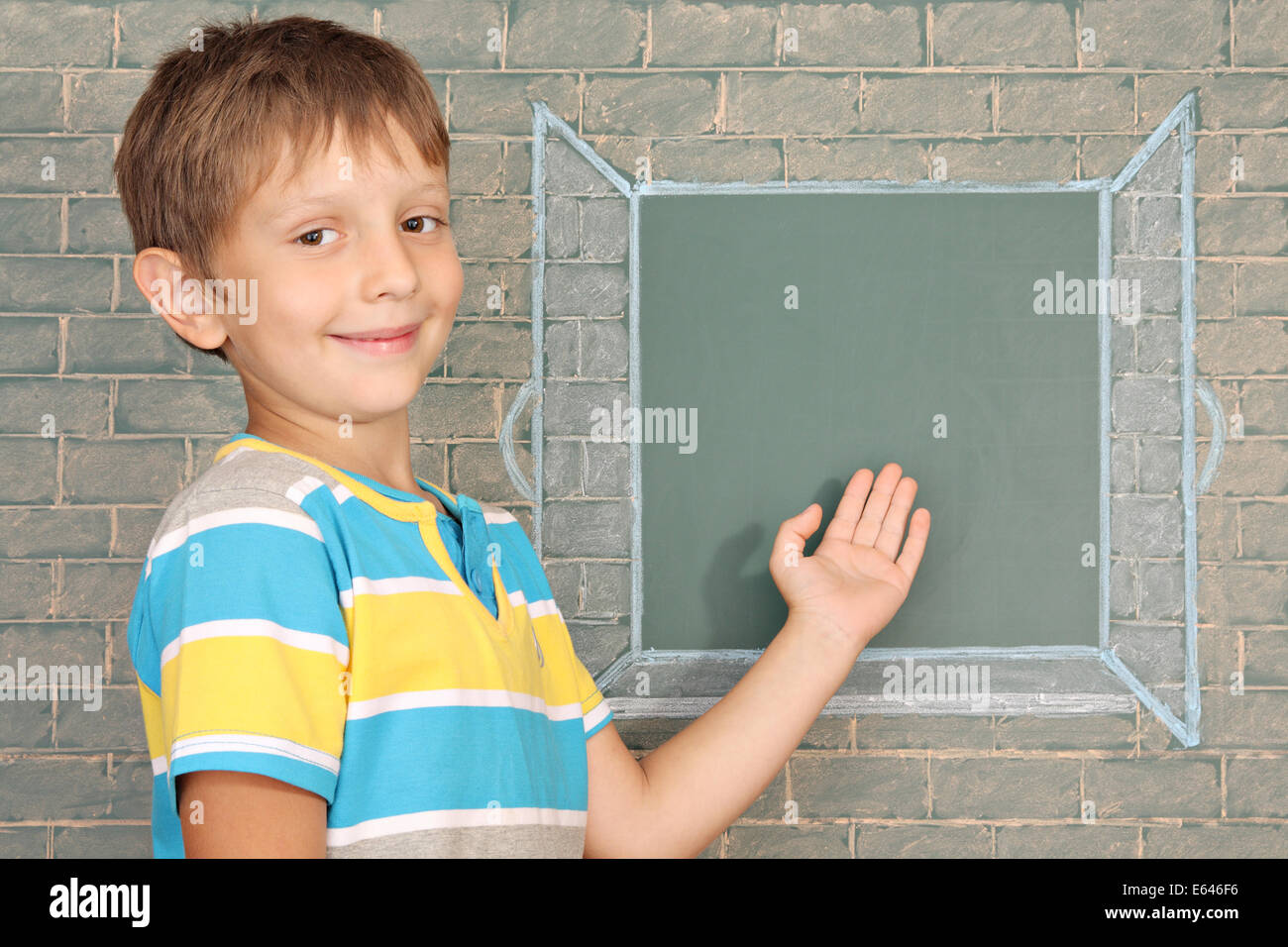 Il schoolboy mostra sulla finestra aperta disegnati su una lavagna Foto Stock