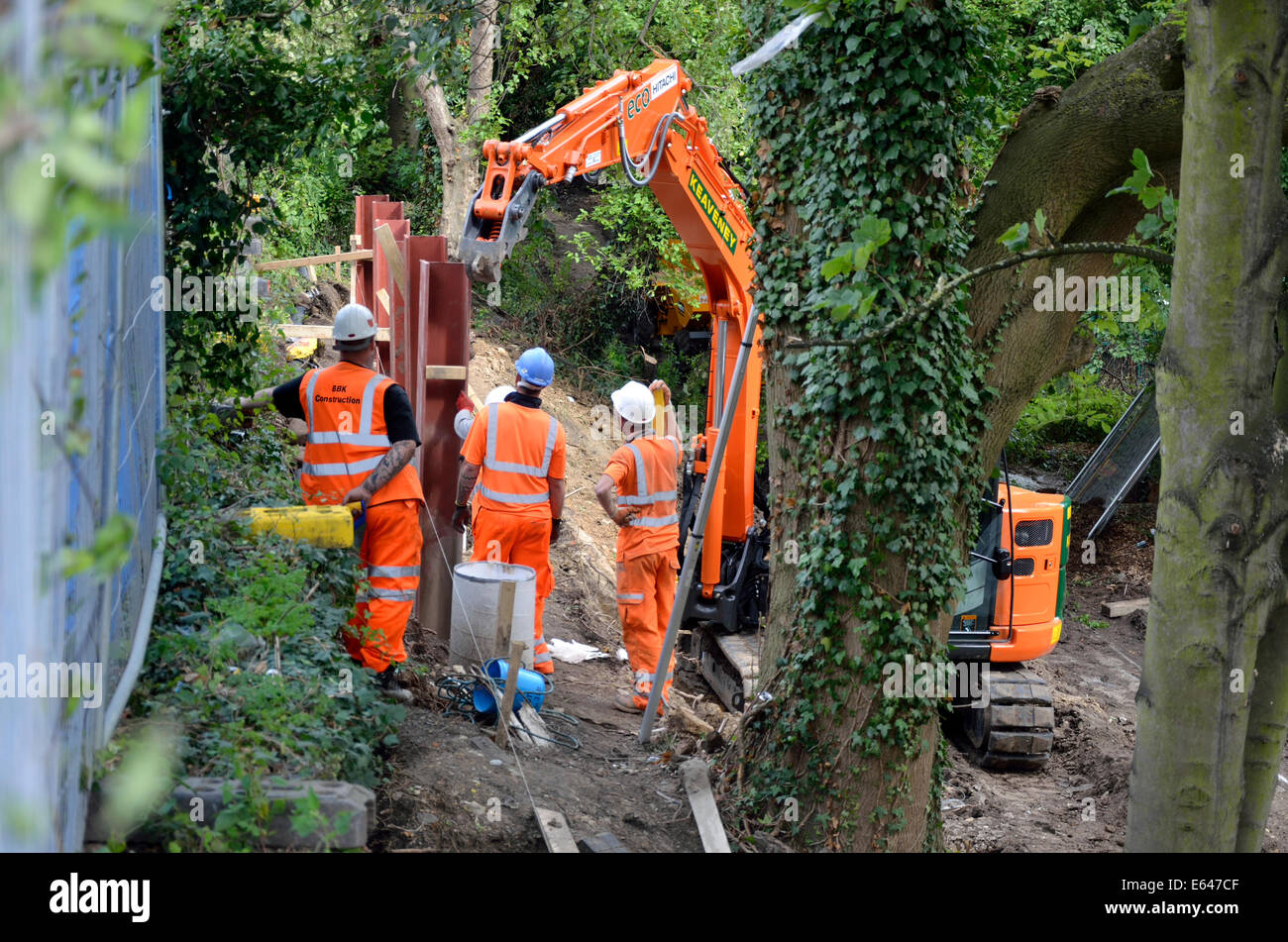Maidstone Kent, Inghilterra. Lavoratori affondamento dei pali nel terreno in pendenza accanto alla linea ferroviaria Foto Stock
