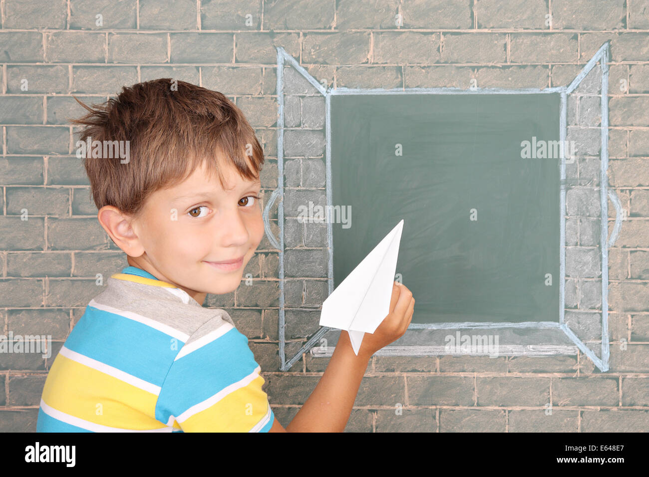 Il scolaro la carta di partenza piano nella finestra aperta disegnati su una lavagna Foto Stock