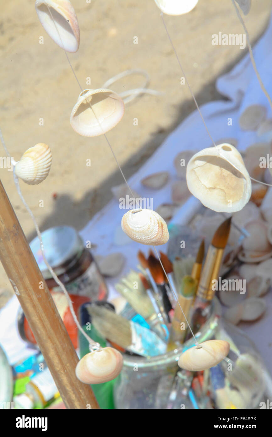 Arti e Mestieri del concetto. Pennelli per dipingere, vernici e conchiglie  sulla spiaggia Foto stock - Alamy