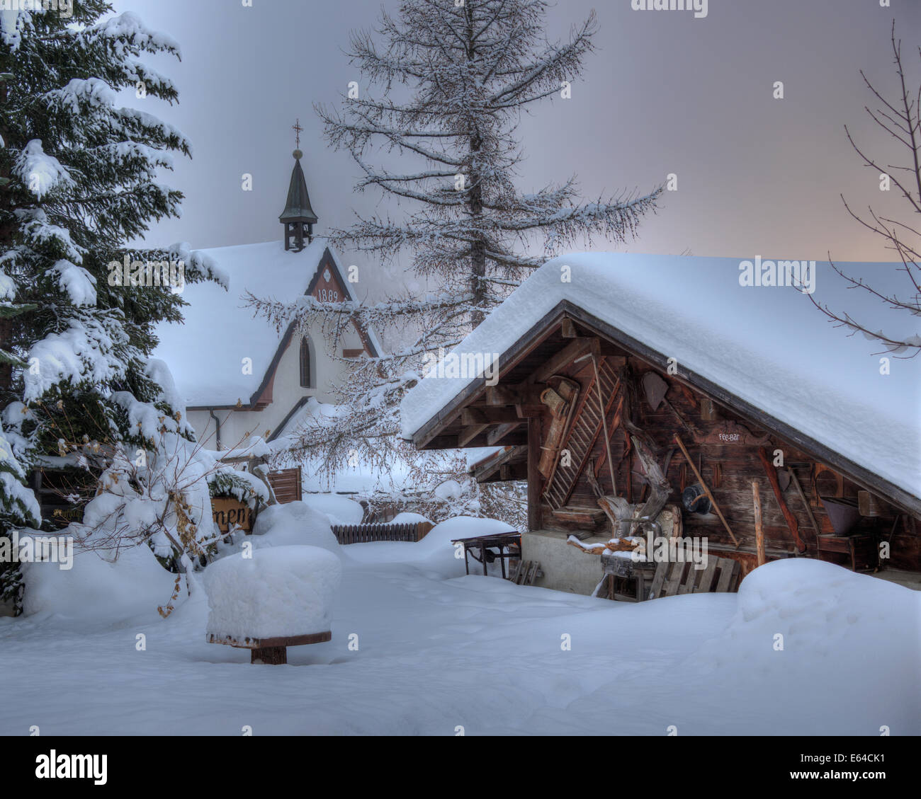 Coperta di neve casa e la cappella in Svizzera al villaggio alpino di Saas-Fee Foto Stock