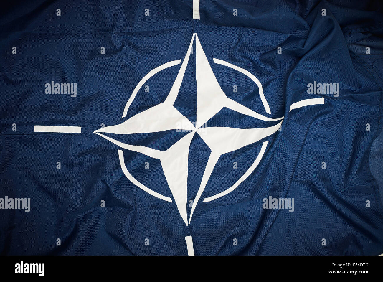 Bandiera dell'Organizzazione del Trattato del Nord Atlantico (NATO) consiste di un blu scuro campo caricato con una bussola bianca rose emblema, con quattro linee bianche che si irradiano da quattro direzioni cardinali. Foto Stock