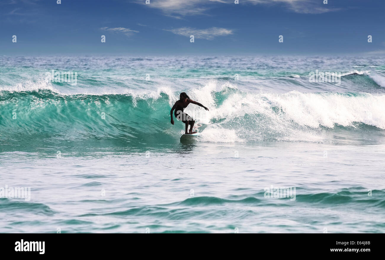 Silhouette di un surfista sulle onde sulla famosa spiaggia in Sri Lanka. Foto Stock