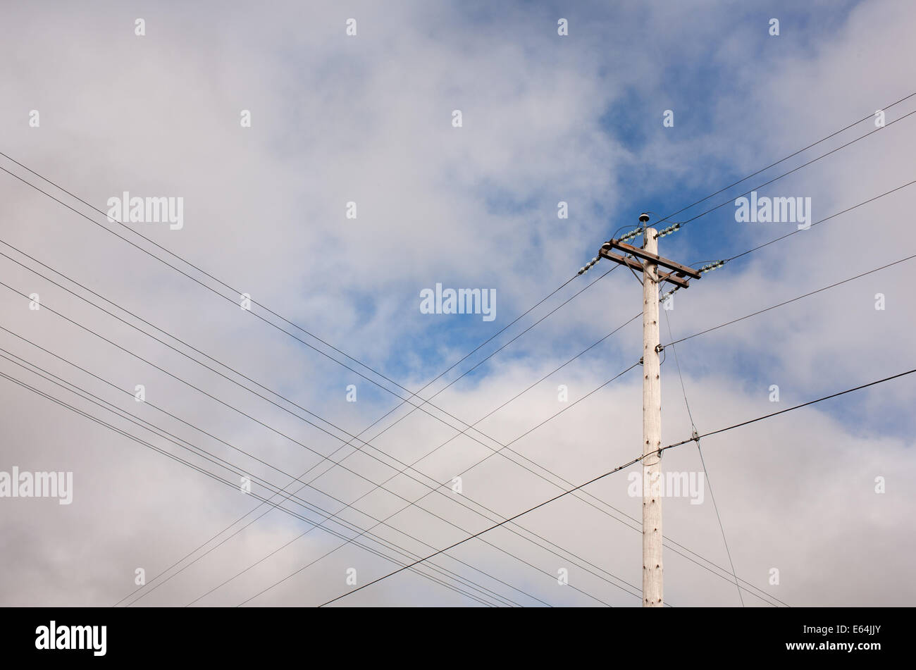 In legno palo telefonico e parzialmente nuvoloso sky. Foto Stock
