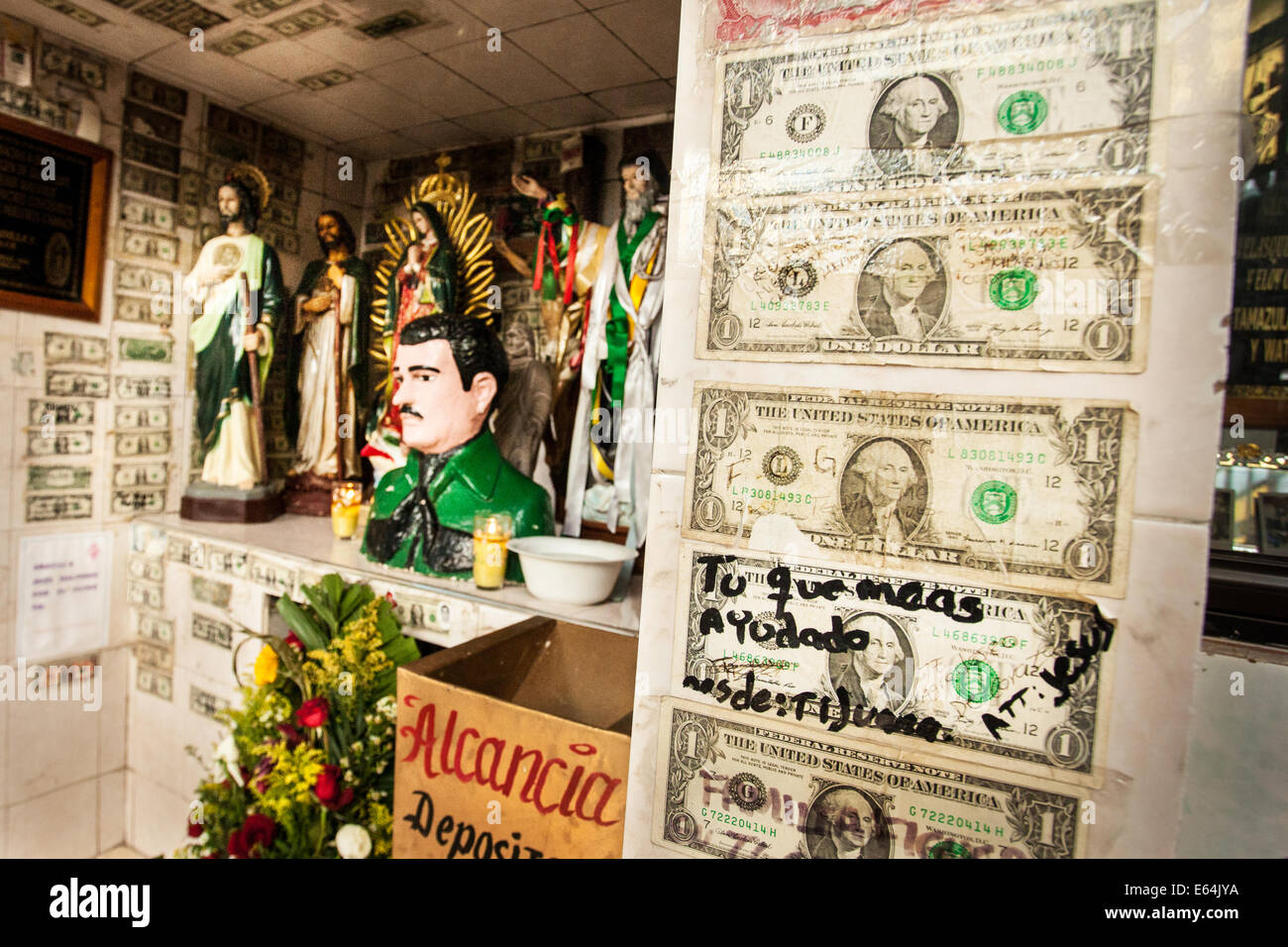 Le fatture del dollaro, uno con il messaggio 'è che ci hanno aiutato la maggior parte", coprire la parete di un santuario dedicato a Gesù Malverde in Messico. Foto Stock