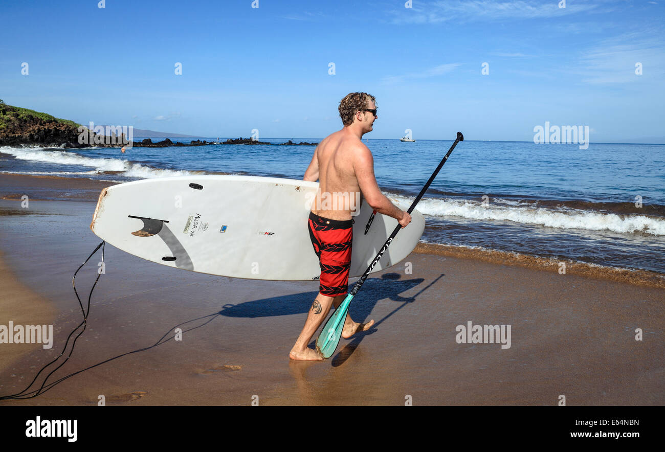 Uomo con stand up paddleboard at Wailea Beach, Maui Foto Stock