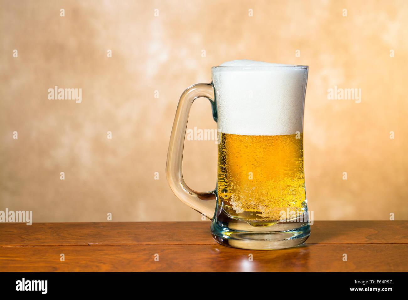 Un freddo, croccante boccale di birra in una pinta tradizionale di vetro con una testa schiumoso Foto Stock