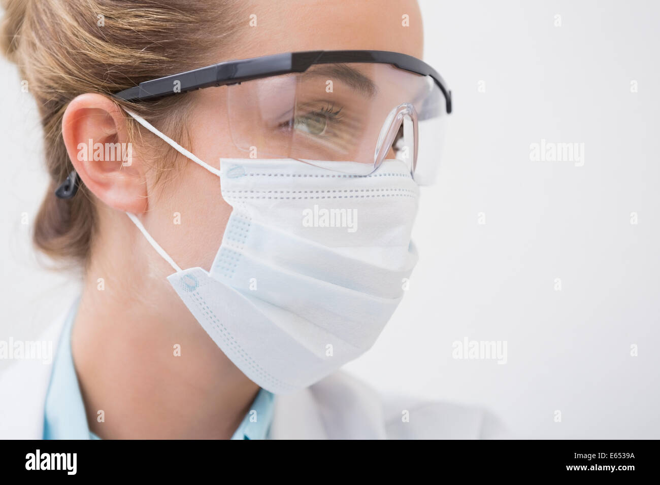 Dentista con mascherina chirurgica e occhiali protettivi Foto stock - Alamy
