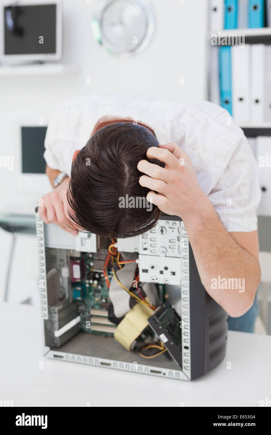 Ingegnere Informatico guardando il dispositivo rotto Foto Stock