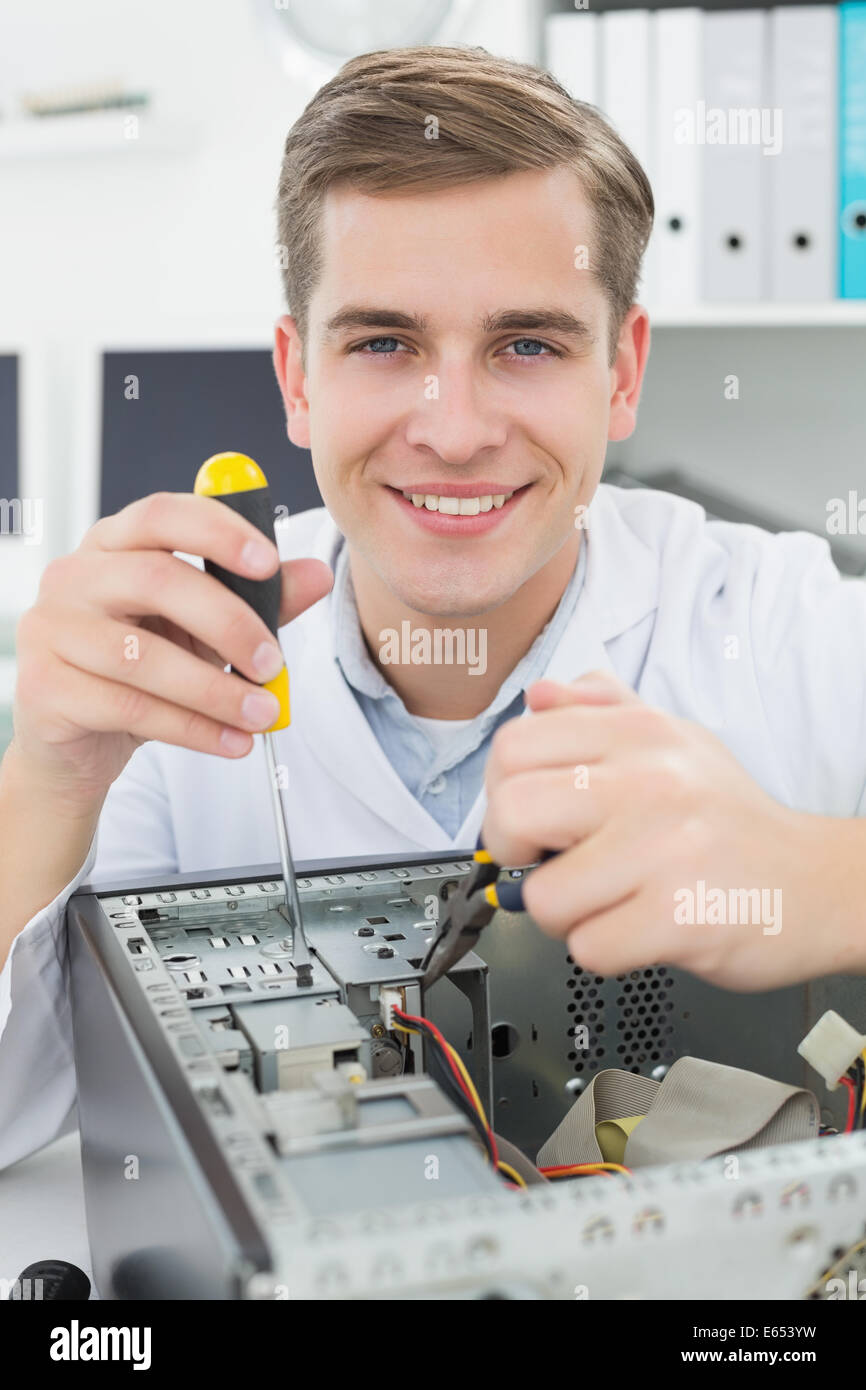 Ingegnere Informatico lavorando sul dispositivo rotto con il cacciavite Foto Stock