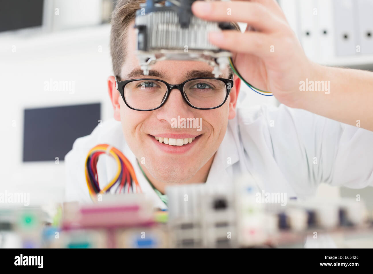 Sorridente tecnico che lavora su cpu guaste Foto Stock