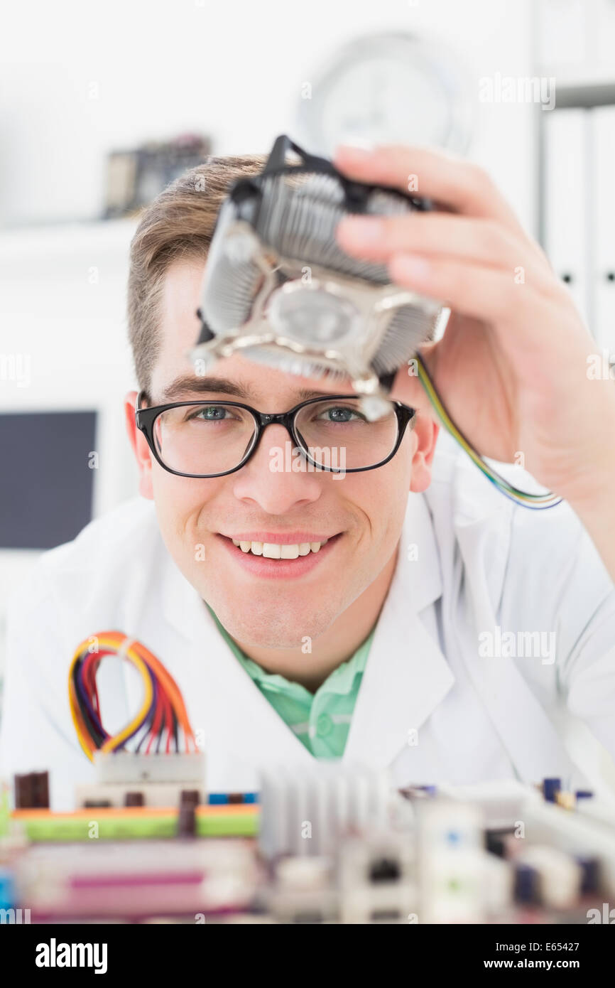 Sorridente tecnico che lavora su cpu guaste Foto Stock