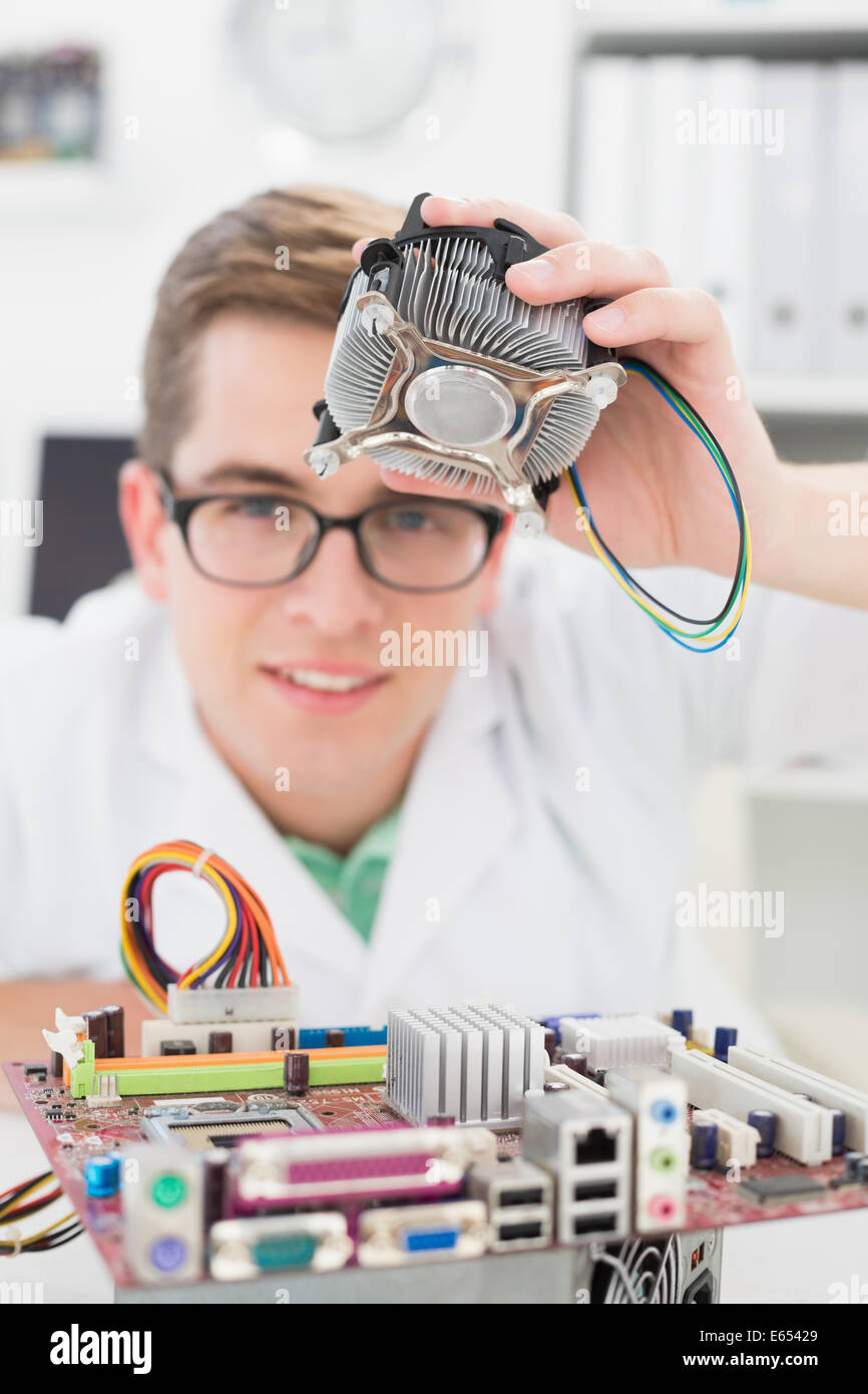 Sorridente tecnico che lavora su ventola rotta Foto Stock