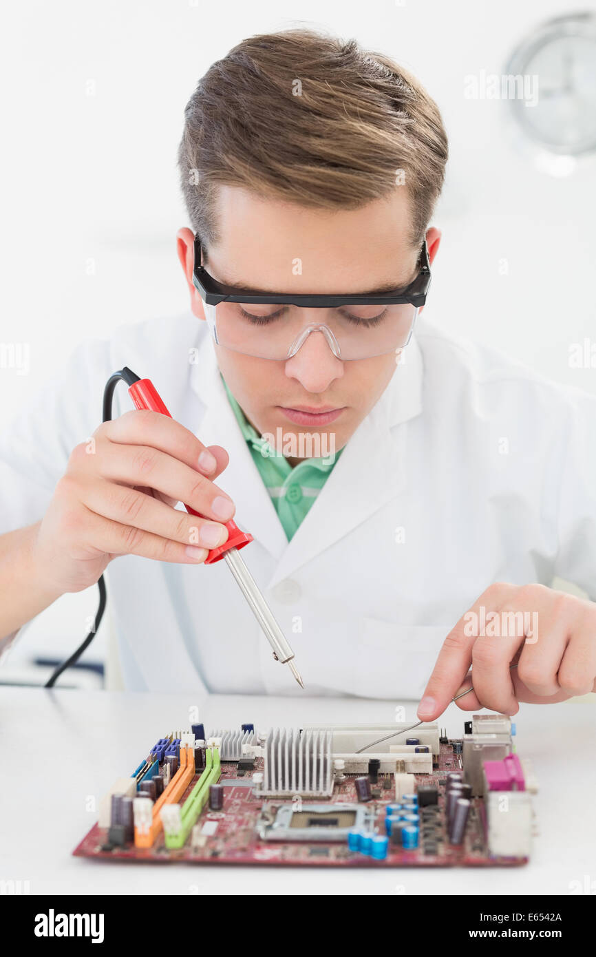 Tecnico che lavora su cpu guaste con saldatore Foto Stock