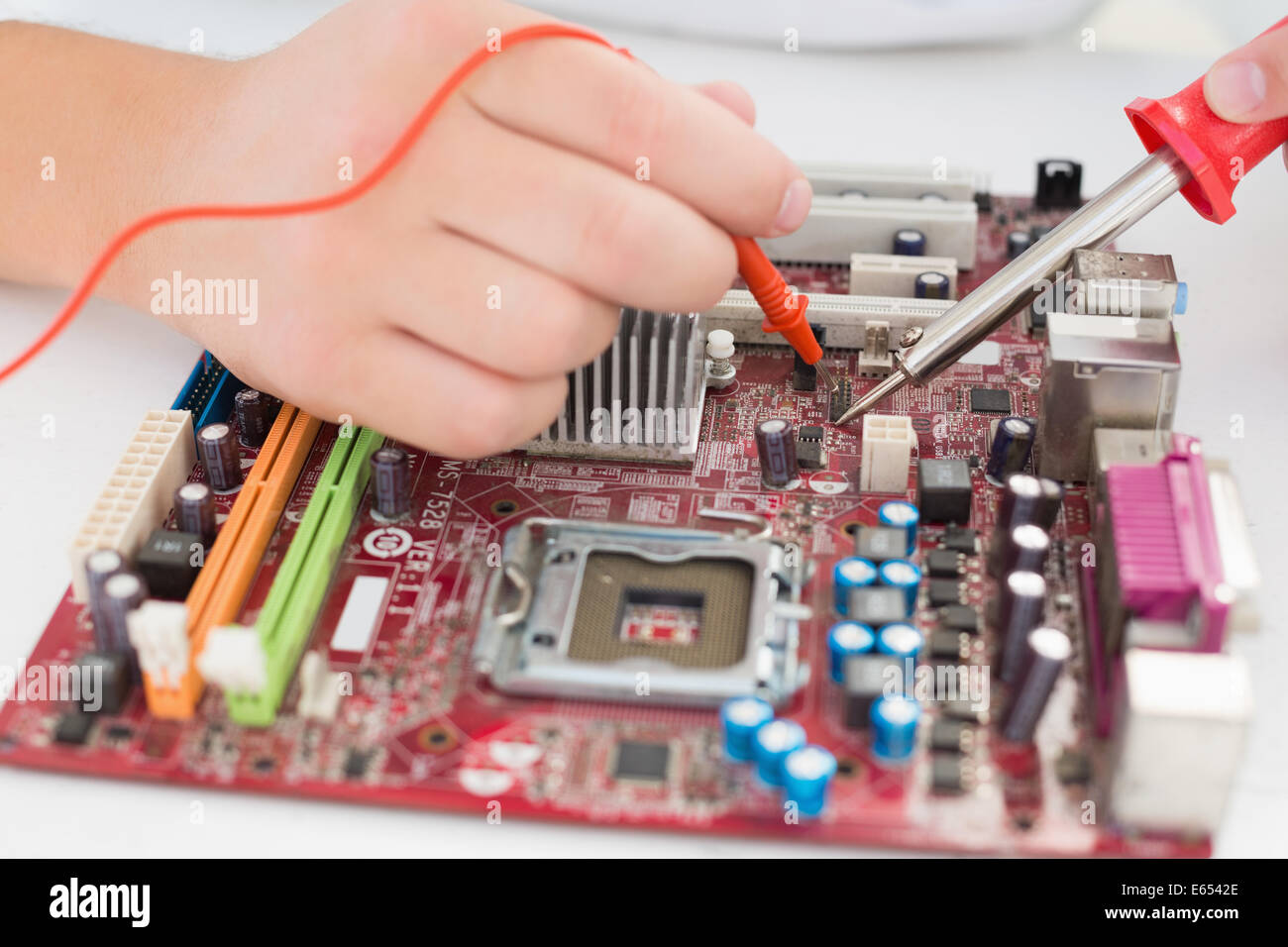 Tecnico che lavora su cpu guaste con saldatore Foto Stock