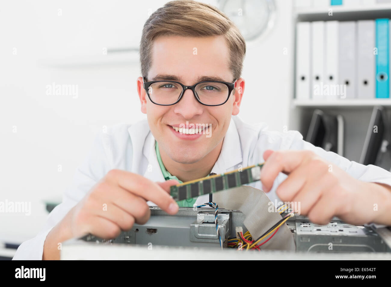 Sorridente tecnico che lavora su cpu guaste Foto Stock