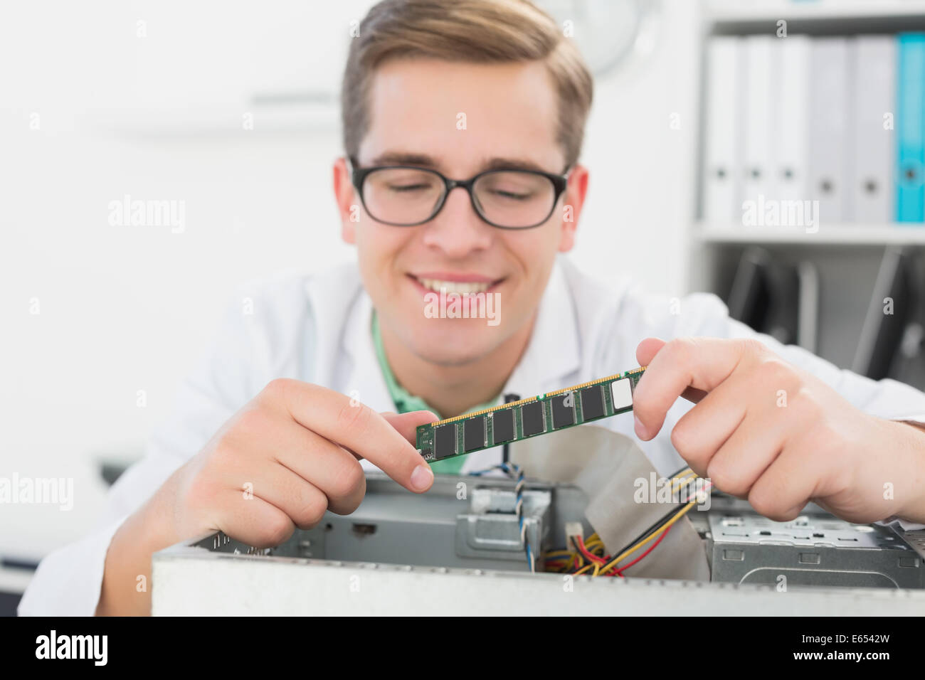 Sorridente tecnico che lavora su cpu guaste Foto Stock