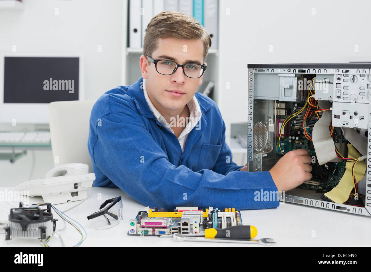 Giovane tecnico che lavora su computer rotto Foto Stock