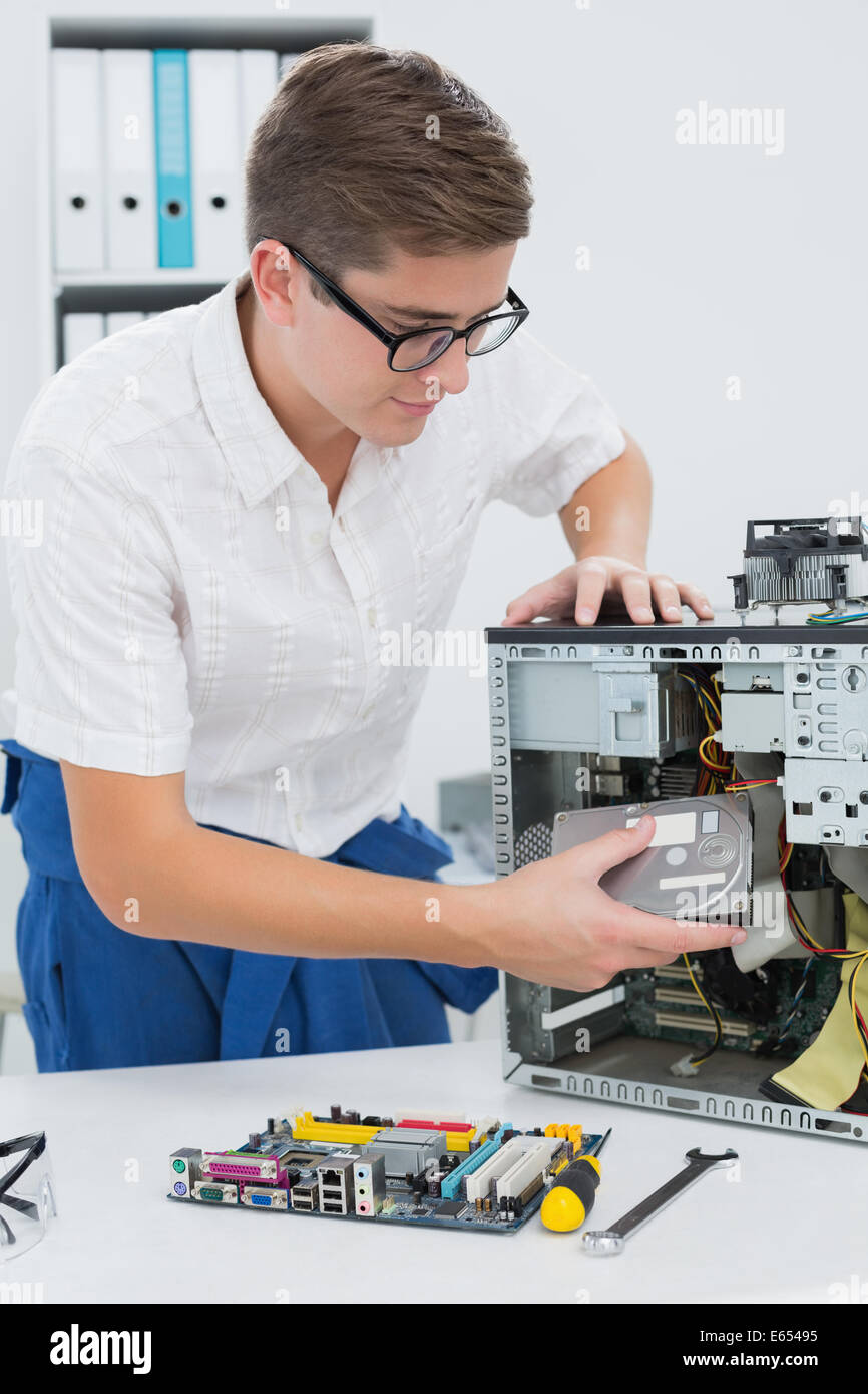 Giovane tecnico che lavora su computer rotto Foto Stock