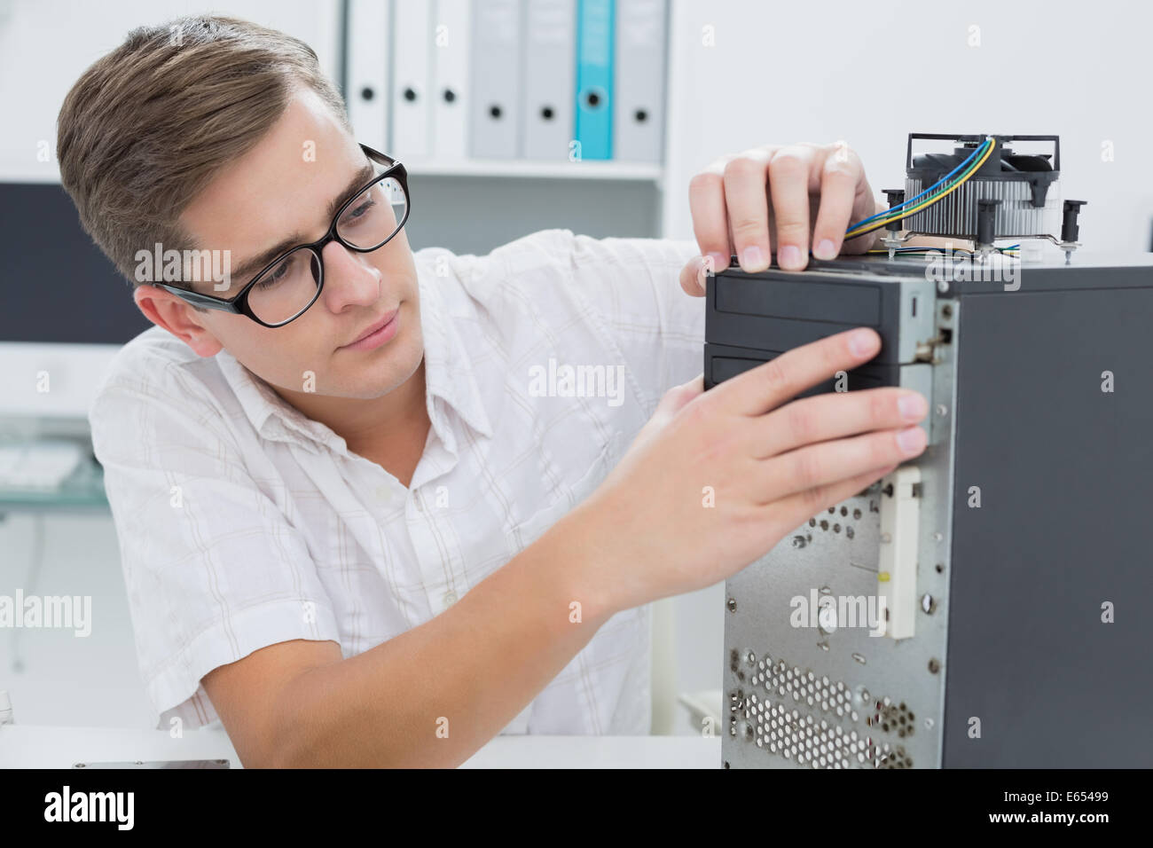 Giovane tecnico che lavora su computer rotto Foto Stock