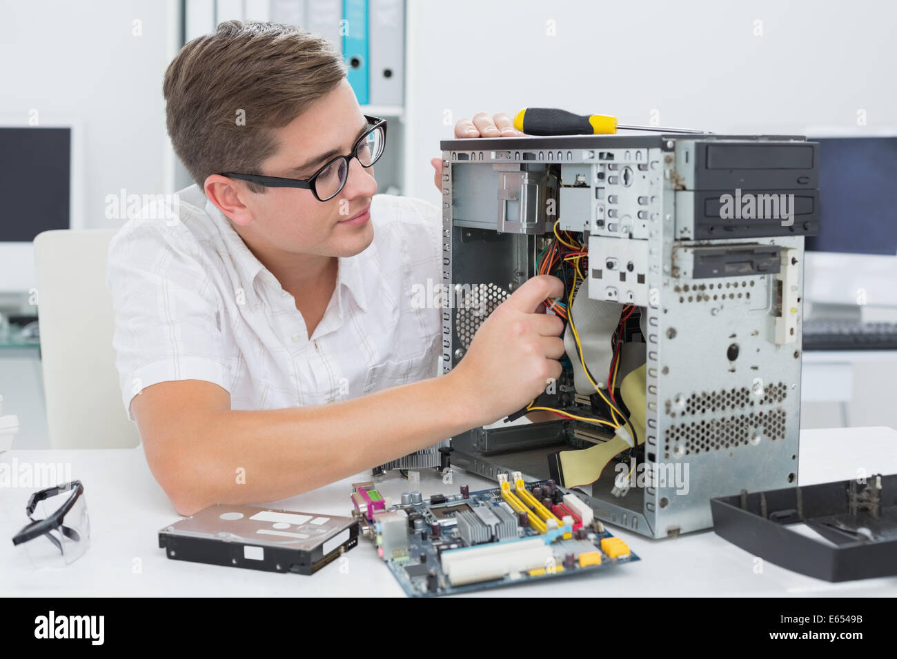 Giovane tecnico che lavora su computer rotto Foto Stock