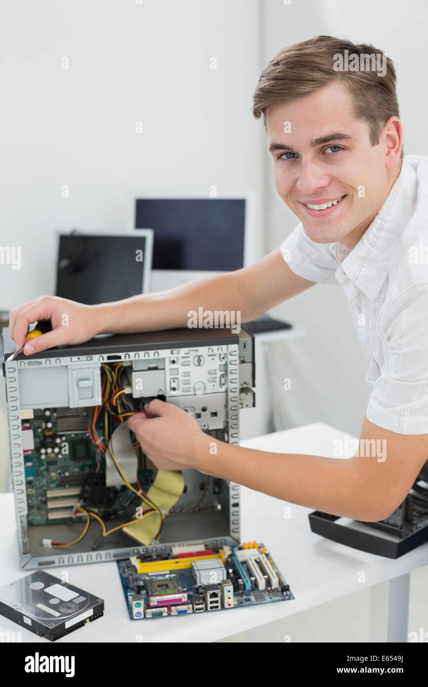 Giovane tecnico che lavora su computer rotto Foto Stock