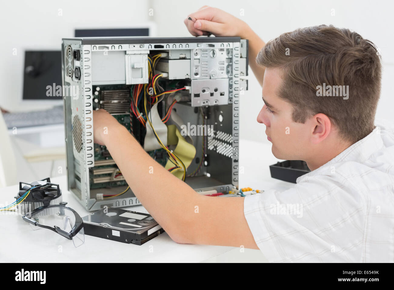 Giovane tecnico che lavora su computer rotto Foto Stock