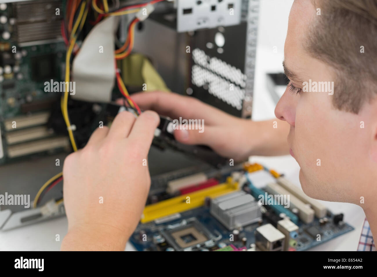 Giovane tecnico che lavora su computer rotto Foto Stock