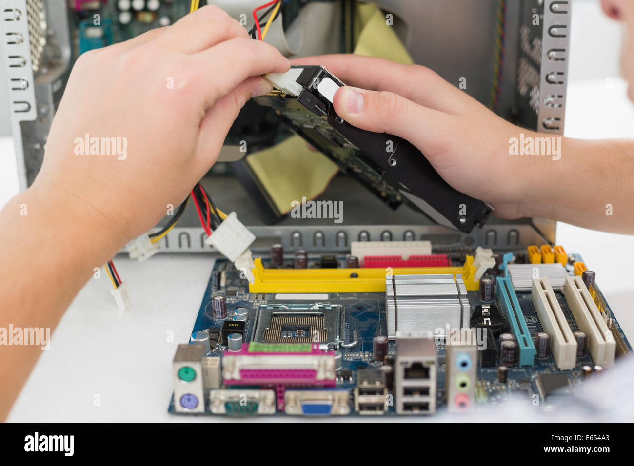 Giovane tecnico che lavora su computer rotto Foto Stock