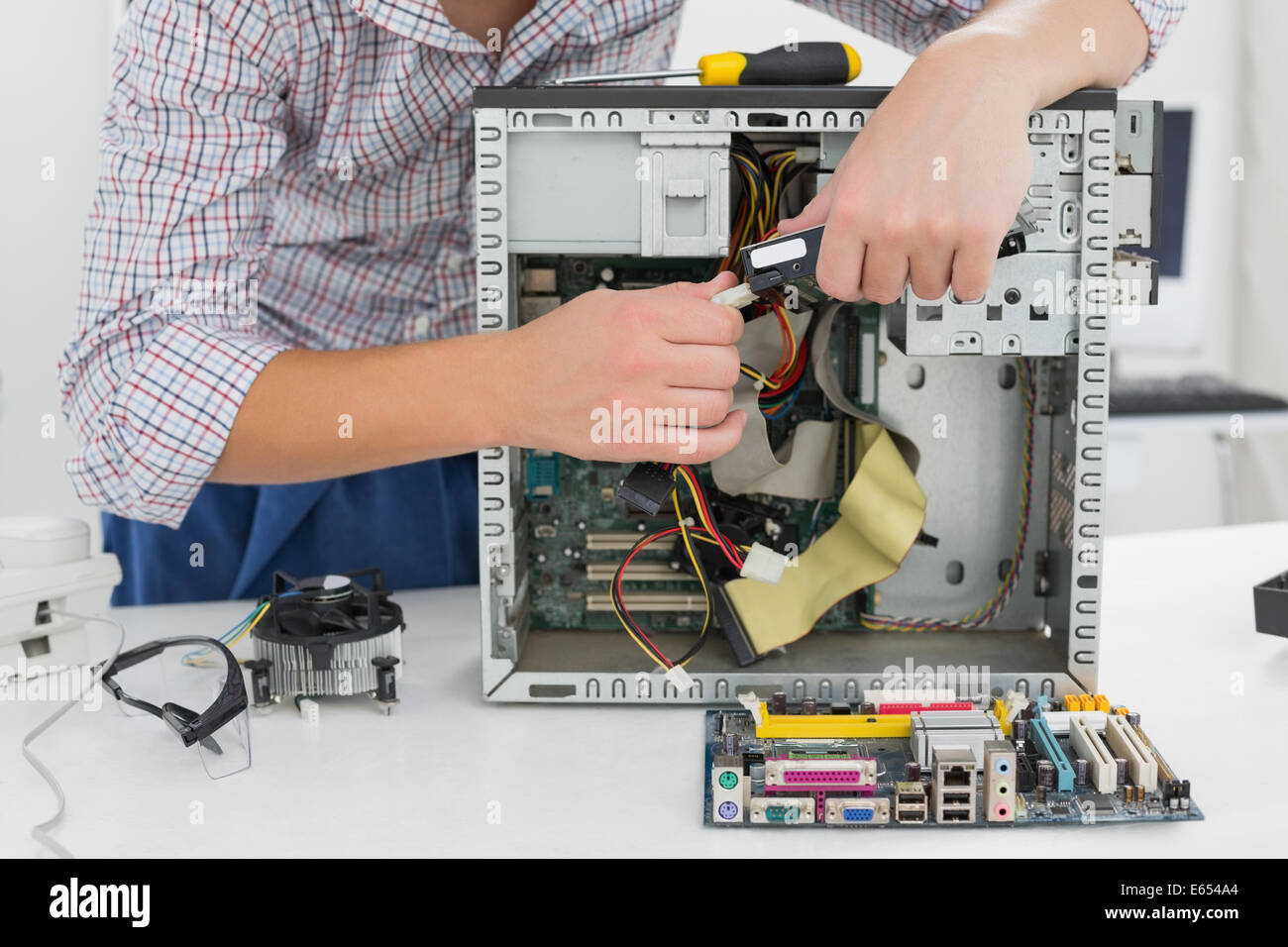 Giovane tecnico che lavora su computer rotto Foto Stock
