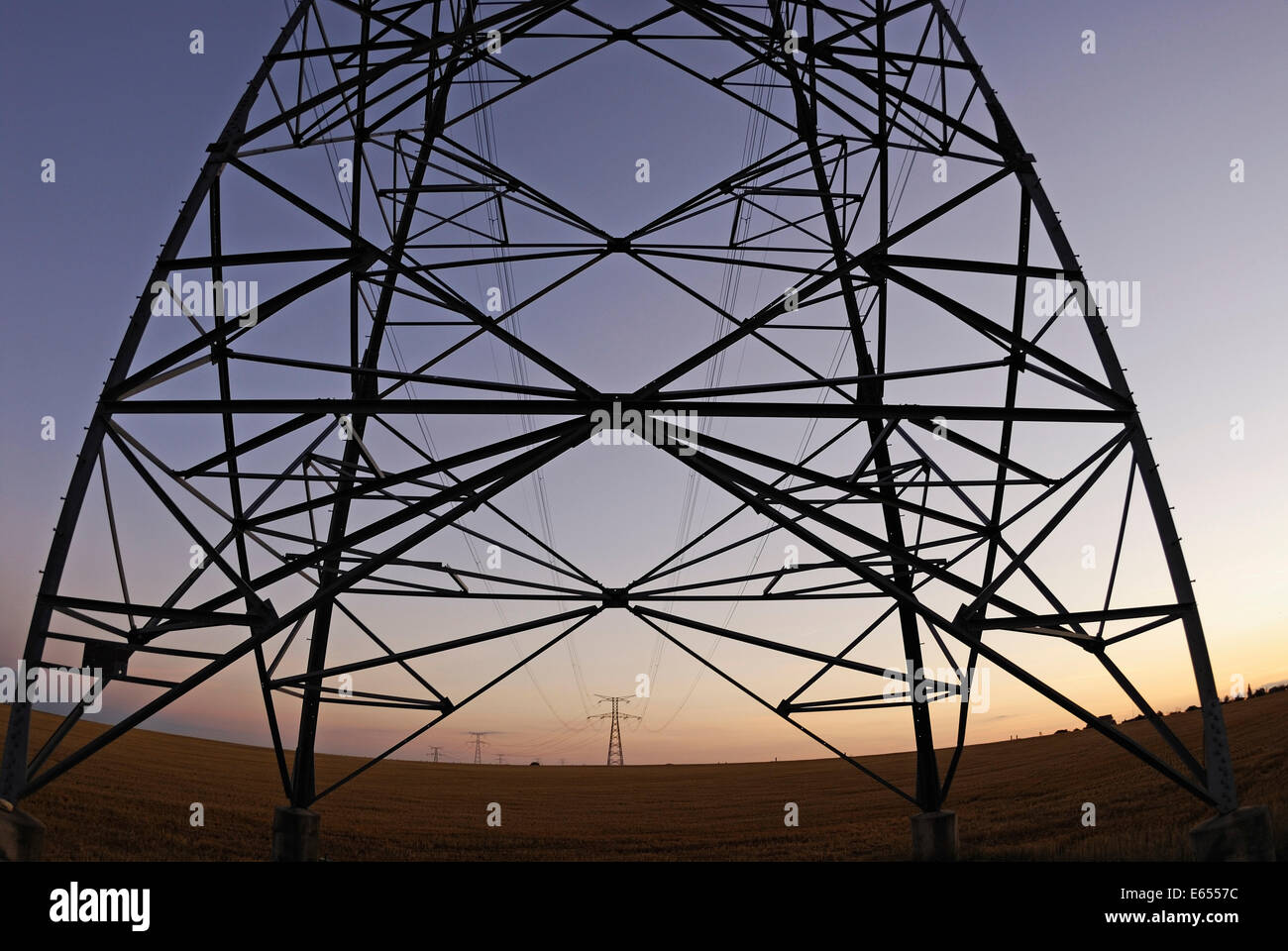 Tralicci di energia elettrica al tramonto, Francia Foto Stock
