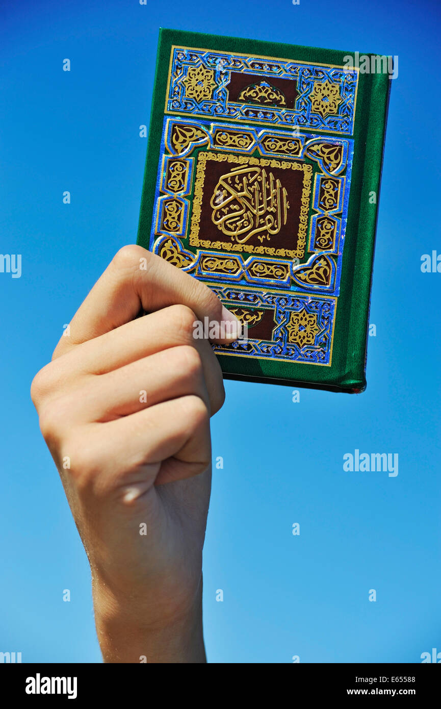 Mano che tiene il Corano il Corano libro sacro Foto Stock