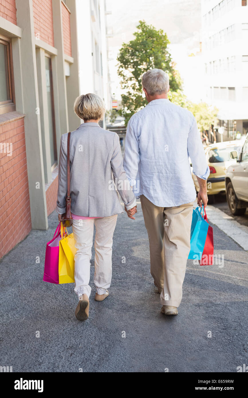 Felice Coppia matura a piedi con i loro acquisti Foto Stock