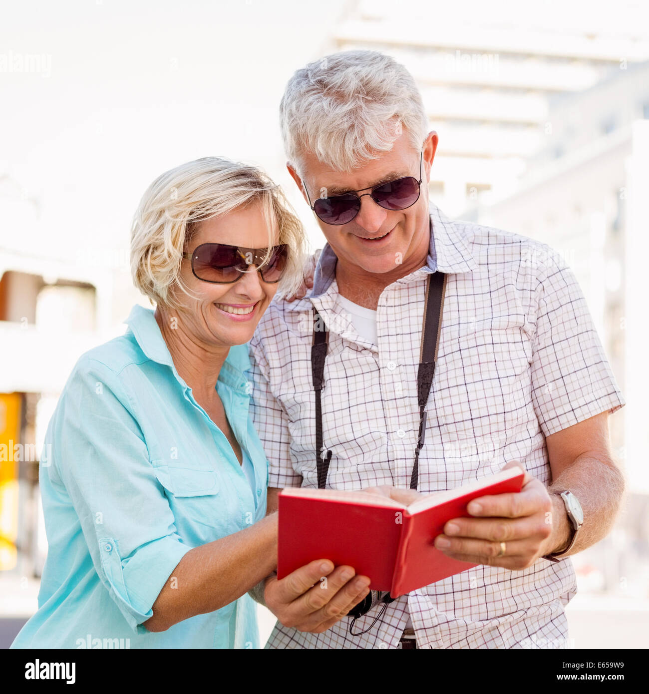 Felice coppia turistico utilizzando tour libro guida in città Foto Stock