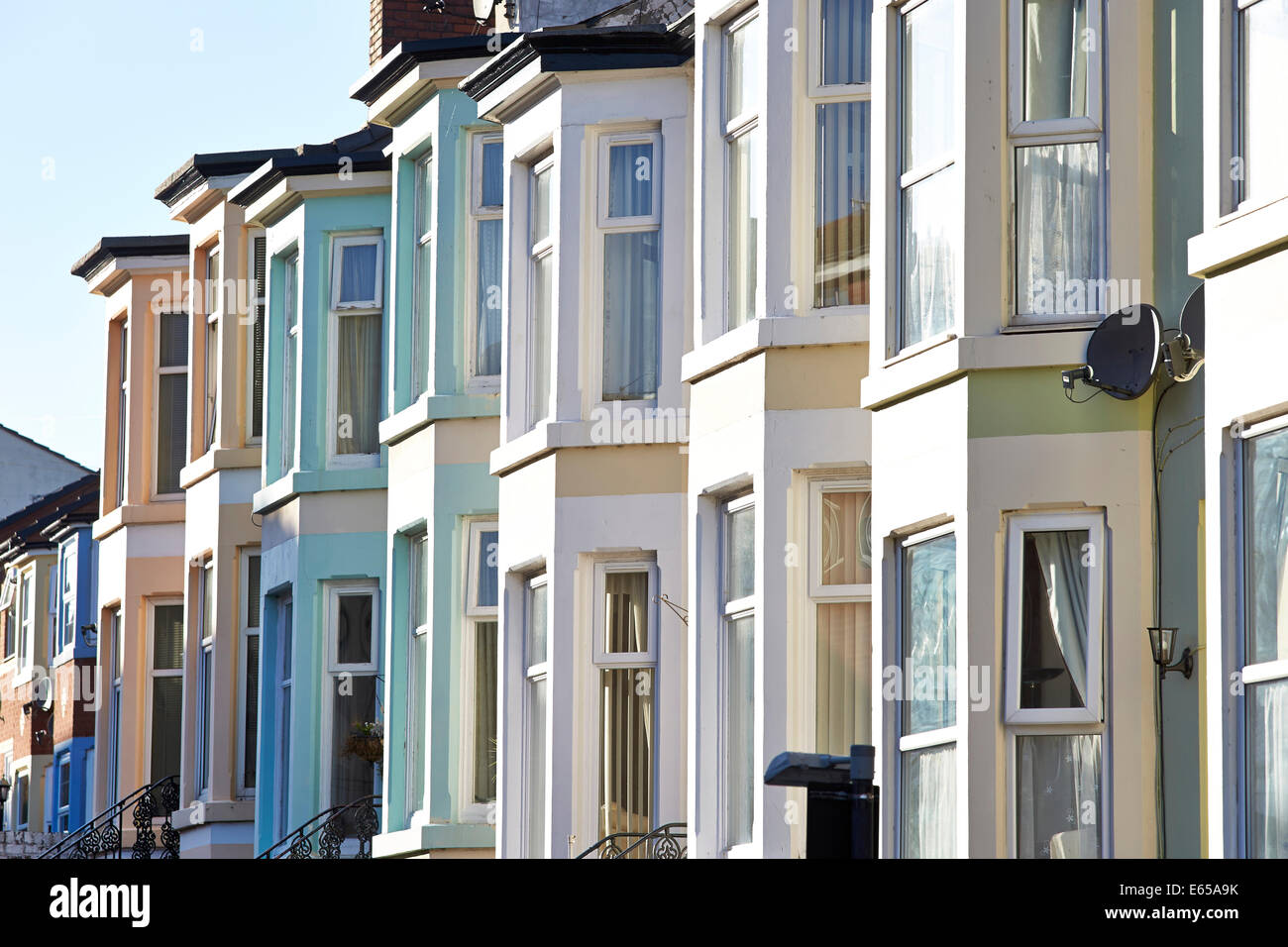 Parte anteriore del dipinto di case terrazza nella foto durante l'estate in un Regno Unito strada residenziale. Foto Stock