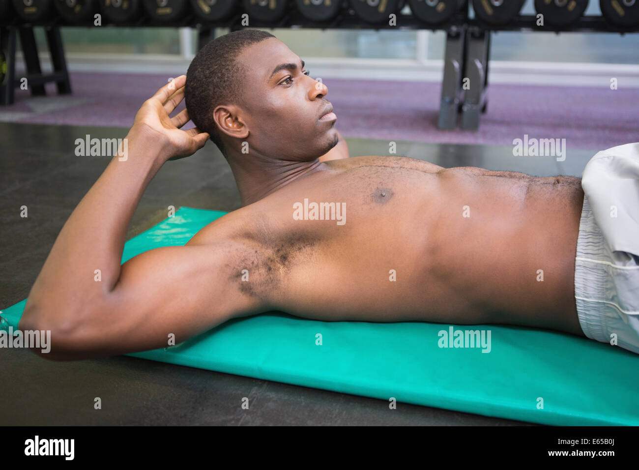 Shirtless uomo facendo sgranocchia addominale in palestra Foto Stock