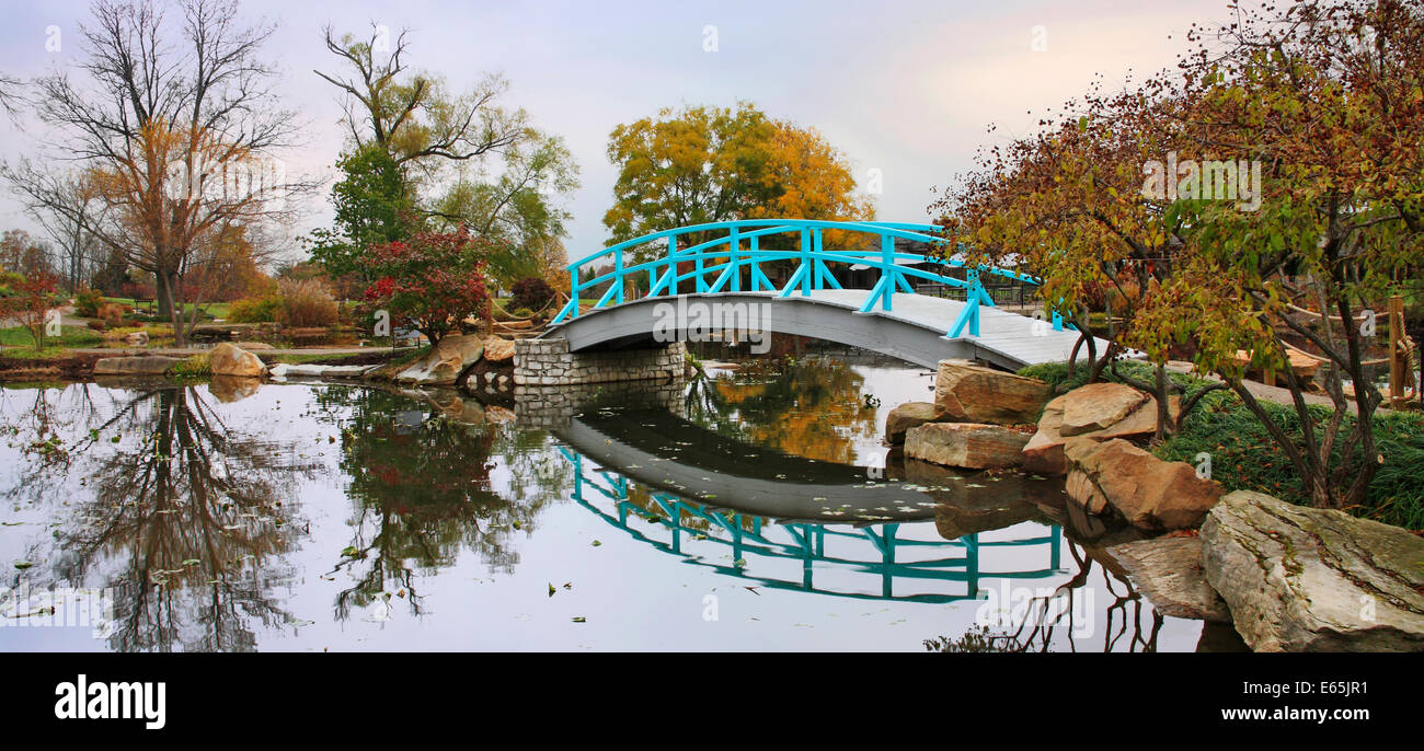 Una scena pastorale di un piede giapponese ponte su un tranquillo laghetto in un giorno di pioggia in autunno, Southwestern Ohio, Stati Uniti d'America Foto Stock