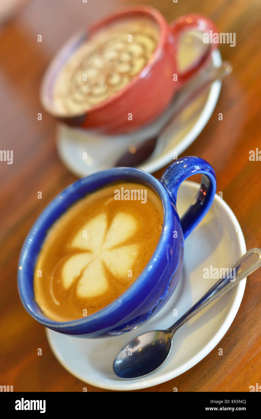 Tazze di caffè con latte su un tavolo di legno. Foto Stock