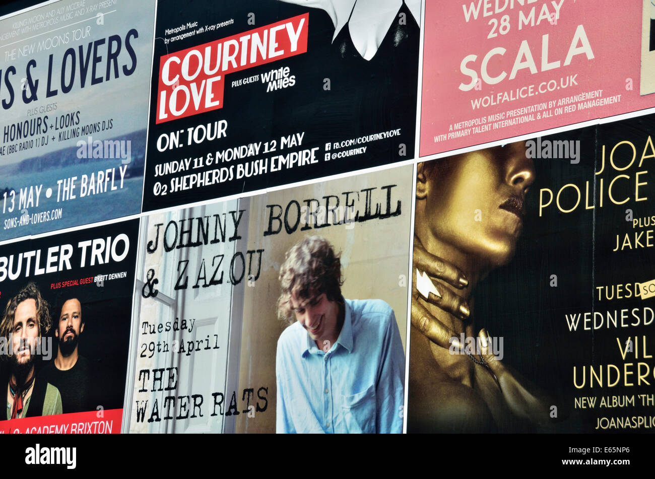 Poster su una parete pubblicità concerti pop e rock, Camden Town, Londra, Regno Unito. Foto Stock