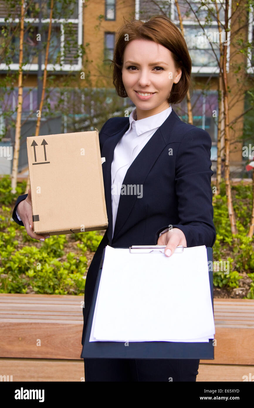 Business Woman holding negli appunti e scatola di cartone. Foto Stock