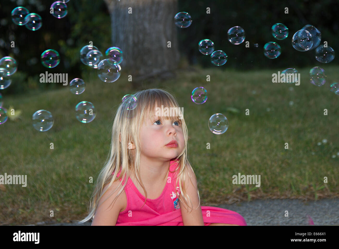 Ragazza giovane fantasticando e giocando con bolle Foto Stock