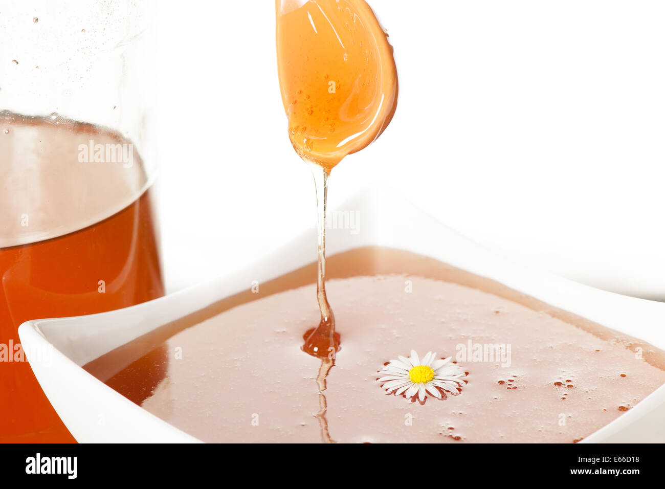 Un cucchiaio colmo di miele isolato su bianco Foto Stock