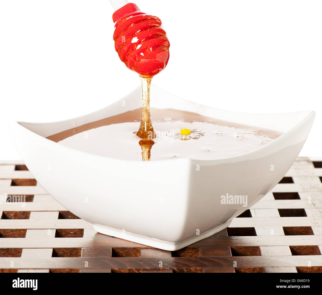 Un cucchiaio colmo di miele isolato su bianco Foto Stock