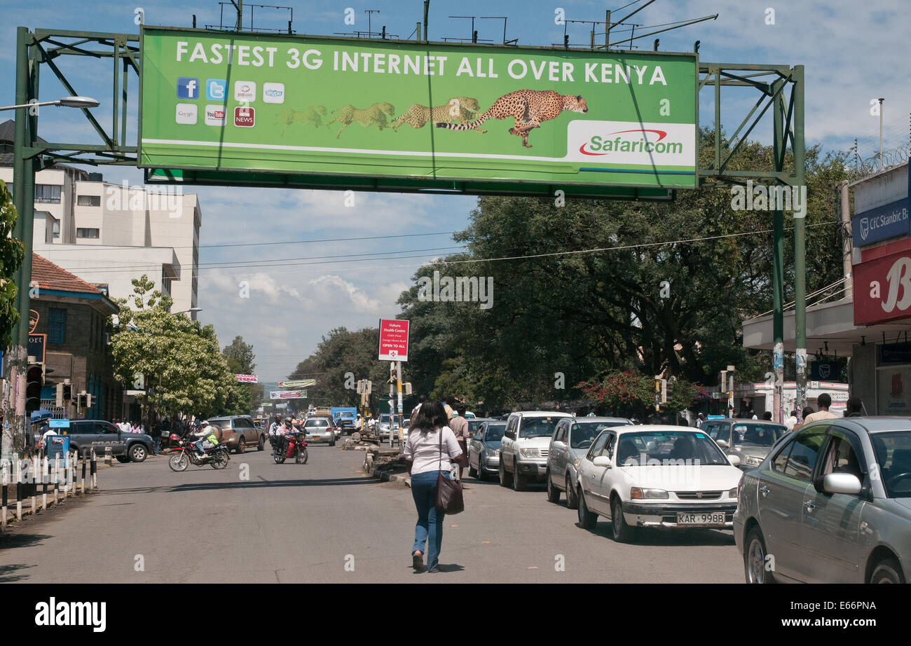 Traffico di persone e di veicoli su Kenyatta Avenue Nakuru Kenya Africa orientale con un cartellone pubblicitario per la rete 3G KENYATTA AVENUE NAKURU Foto Stock