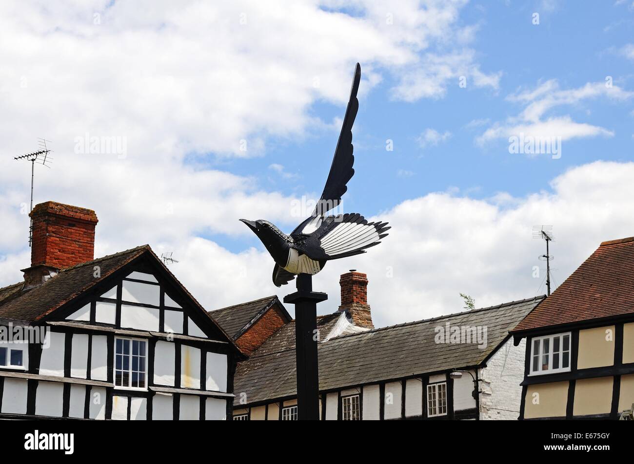 La gazza scultura con bianchi edifici con travi di legno per la parte posteriore, Weobley, Herefordshire, Inghilterra, Regno Unito, Europa occidentale. Foto Stock