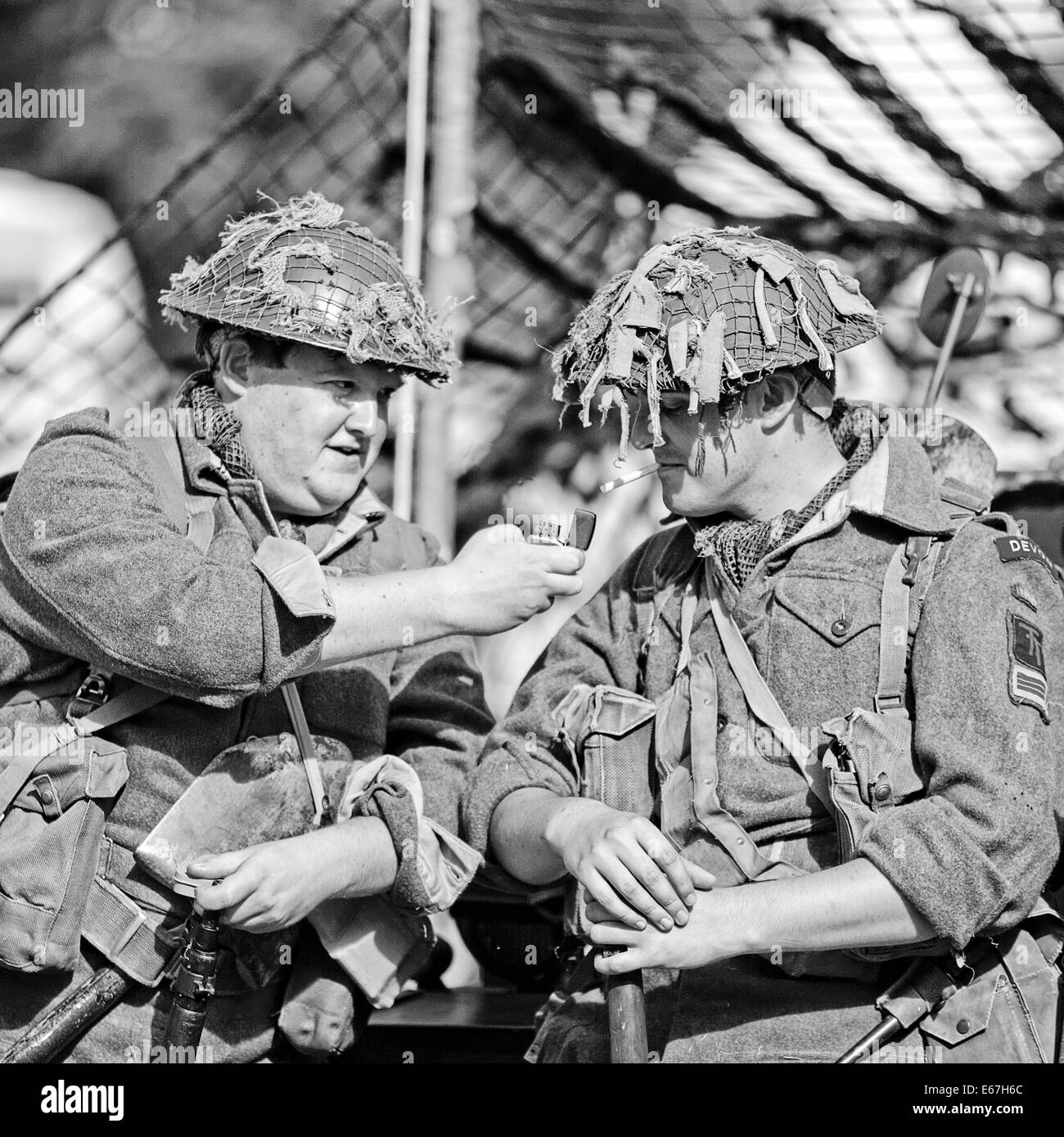 Un fante del Devon - Devonshire reggimento della Seconda Guerra Mondiale utilizza una mostra Zippo alla luce di una sigaretta compagni Foto Stock