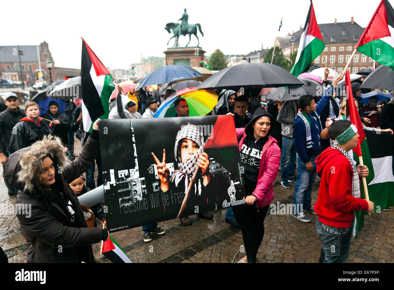 Copenhagen, Danimarca. 17 Agosto, 2014. Nonostante la pioggia battente di centinaia di Copenhagener raccogliere in una pace corrispondono a sostegno dei bambini di Gaza e contro la guerra israeliano nel loro paese. La marcia della pace si è conclusa davanti al parlamento danese, Christiansborg, dopo una durata di 2 ore a piedi attraverso la città. Il testo sul segno nero membri: "Palestina sarà libero'. Credito: OJPHOTOS/Alamy Live News Foto Stock