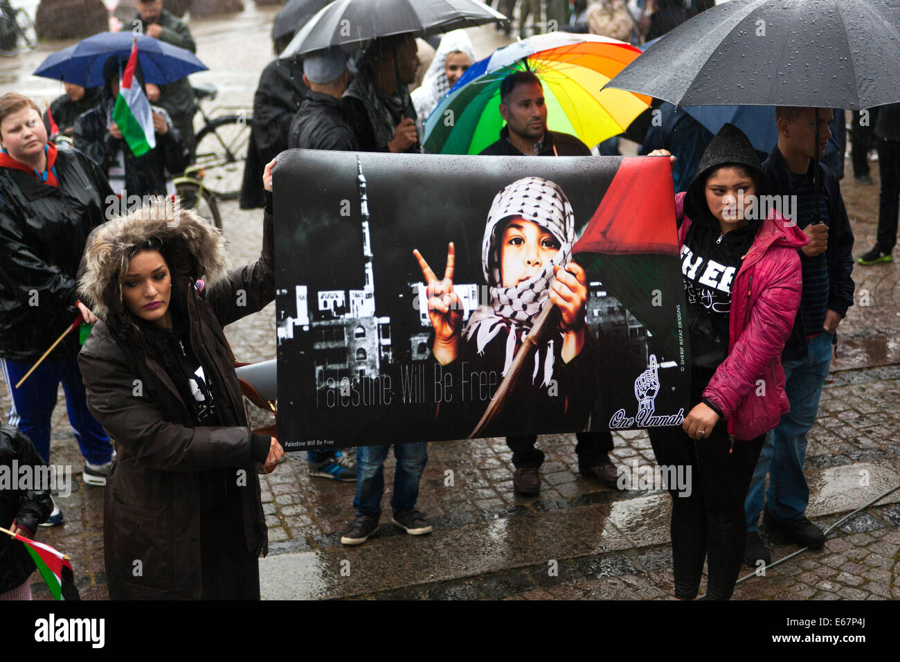 Copenhagen, Danimarca. 17 Agosto, 2014. Nonostante la pioggia battente di centinaia di Copenhagener raccogliere in una pace corrispondono a sostegno dei bambini di Gaza e contro la guerra israeliano nel loro paese. La marcia della pace si è conclusa davanti al parlamento danese, Christiansborg, dopo una durata di 2 ore a piedi attraverso la città. Il testo sul segno nero membri: "Palestina sarà libero'. Credito: OJPHOTOS/Alamy Live News Foto Stock