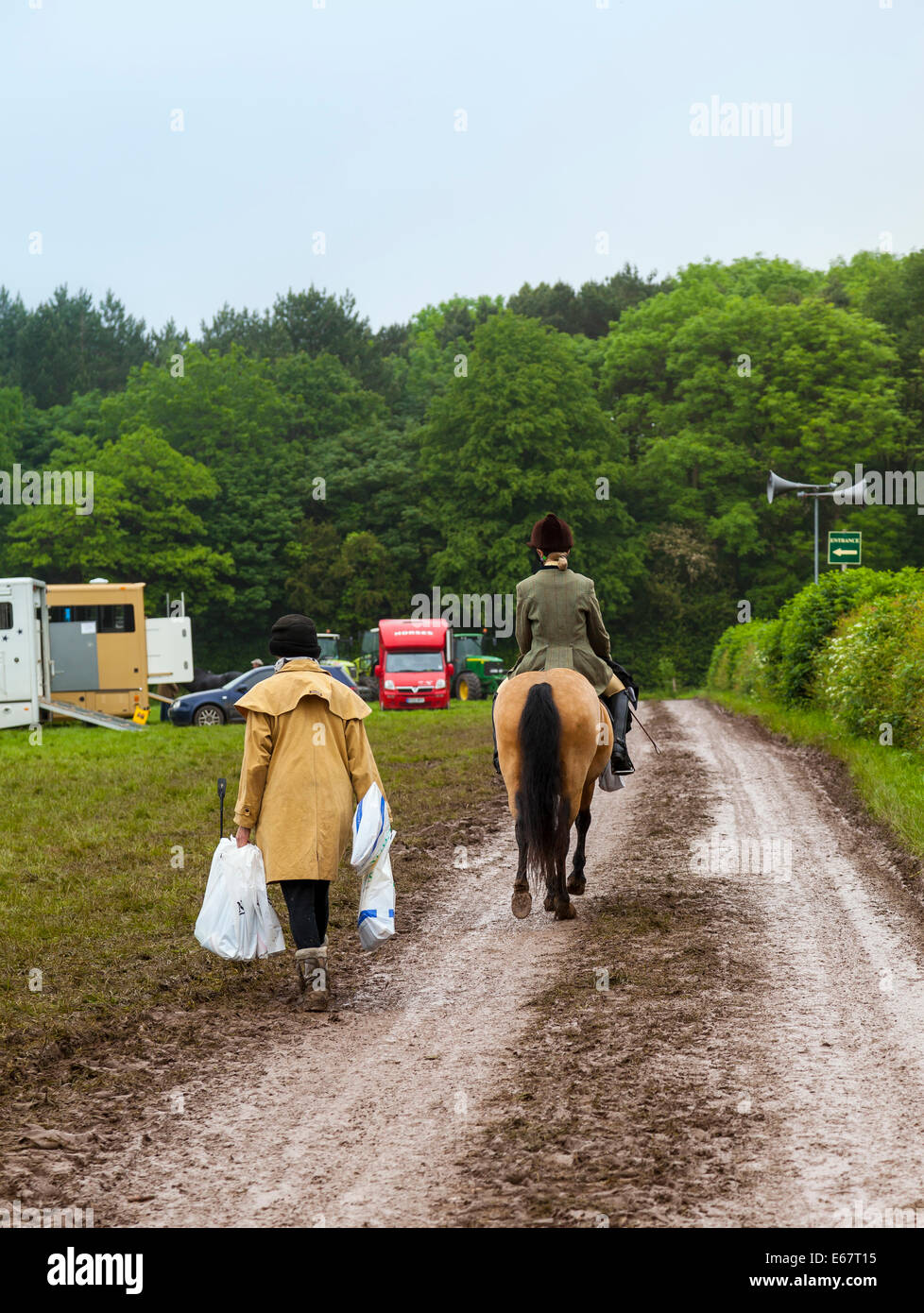 Staffordshire Inghilterra Donna sul cavallo paese giù lane, con la donna più anziana in seguito a piedi, il trasporto delle borse della spesa Foto Stock