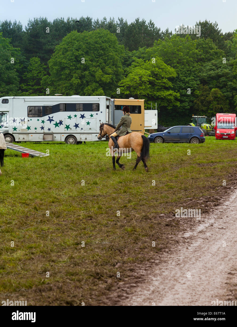 Staffordshire in Inghilterra una donna a cavallo verso van per cavalli in un campo fangoso dopo forti piogge in Staffordshire County Show. Foto Stock